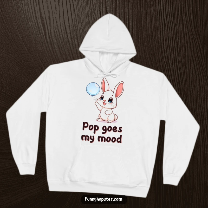 Funny hoodie featuring a playful rabbit with big, happy eyes batting at a floating bubble, radiating warmth and pure delight.